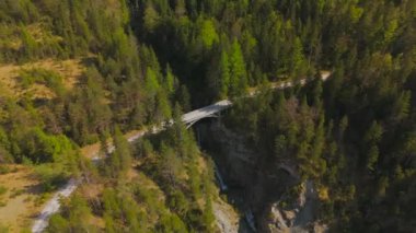 Luftaufnahme Schurpfen Wasserfall. Eğri şelale Schurpfen 'in hava manzarası ve Lenggries' deki Sylvensteinspeicher yakınlarında orman dağı ve kanyonla dolu bir köprü. İnsansız hava aracı görüntüsü düşüyor ve köprü. 
