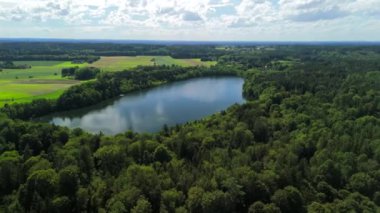 Steinsee bei Munchen Luftaufnahme. Steinsee, Bayern Luftbildansicht 'te. Almanya, Bavyera, Münih yakınlarındaki Stein Gölü hava manzarası. Almanya 'nın en sıcak göllerinden biri. Steinsee orman bölgesinde yer almaktadır.. 