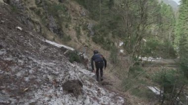 Bisikletçi dağlarda çığ üzerinden bisiklet çekiyor. Bisikletçi engelin içinde sıkıştı ve bisikletini elinde bisikletle bir buz kaydırağının içinden geçiriyor. Alplerdeki bisiklet rotasında çığ. 