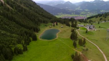 Oberstdorf 'taki hava manzaralı Nebelhorn kar yapma göleti, doğal kar yağışına rağmen kayak faaliyetlerini destekleyen yapay kar için su toplar. Alplerde sürdürülebilir kar örtüsünü desteklemek. 