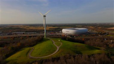Froettmaninger Tepesi 'nin hava manzarası, rüzgar türbini ve Münih' teki Allianz Arena manzarası. Freimann rüzgar santrali ve Münih futbol sahası yukarıdan ele geçirildi. 