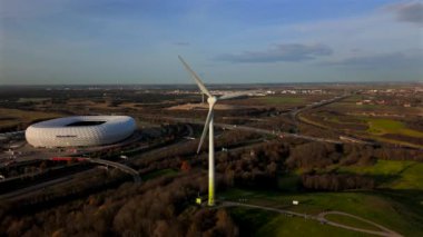 Rüzgâr türbinli Froettmaninger Mullberg 'in hava görüntüsü ve Münih' teki Allianz Arena 'nın net bir görüntüsü. Freimann rüzgar türbini ve Münih futbol arenasının kuş bakışı perspektifi. 
