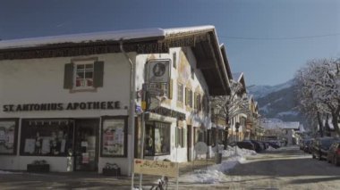 25 Aralık 2024. Garmisch-Partenkirchen, Almanya. Güneşli bir kış günü, karlı sokaklar, kapalı dükkanlar, yayalar, gezinen insanlar olan huzurlu bir kasaba. Garmisch Partenkirchen şehir merkezinde.