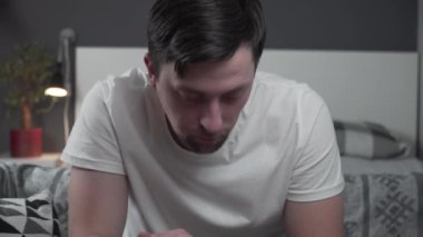 Adam evde kanepede oturuyor, iki eliyle boynunu tutuyor, acı içinde yüzünü buruşturuyor. Keskin boyun ağrısından muzdarip. Sinir sıkışması, rahim fıtığı ya da gerginlikten kaynaklanıyor.. 