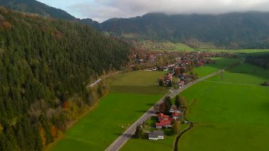 Almanya 'nın Bayrischzell istasyonuna gelen bir trenin sonbahar hava görüntüsü. Sahne altın ağaçlar ve keskin bir sonbahar gününde nefes kesici Bavyera manzaralarıyla dolu.
