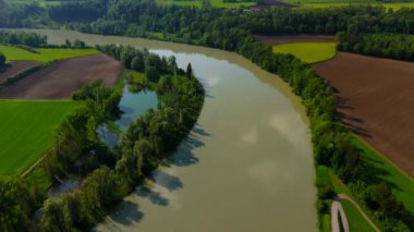 River Inn 'in, güneşli yaz havasında Muhldorf am Inn yakınlarındaki tarım arazileri ve doğa manzarası. Bavyera, Almanya Nehir Hanı otlakları ve kırsal alan manzaralı. Tarım arazisi havası. 