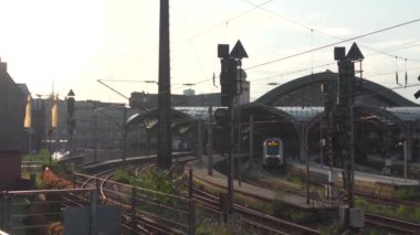 Nordrhein-Westfalen Deutschland 'dan Koln Hauptbahnhof. Almanya 'da Köln' ün ana istasyonu yazın gün batımında şehir merkezinde Köln Katedrali 'nin yanındaki raylar, raylar ve çatı manzarası dışında yer almaktadır.. 