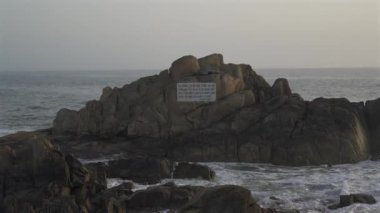 Farol da Boa Nova Portekiz, Porto 'da. Miradouro da Boa Nova. Okyanusta Capela da Boa Nova yakınlarında Oporto, Portekiz 'de gün batımında plakalı bir kaya. Hatıra mermer plaketi Antonio Nobre. 