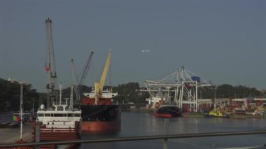 Porto, Portekiz. Oporto 'da güneşli havalarda vinçleri ve işçileri olan kargo limanı. Köprüden kargo gemileriyle yükleme terminali görünüyor. Küresel iş lojistik ve ulaşım. 