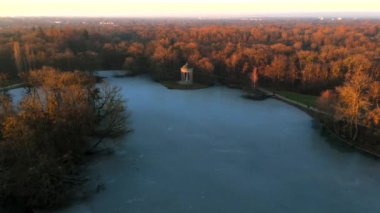 Apollotempel Muenchen im Schlosspark Nymphenburg, Alman Luftbildaufnahme. Almanya 'da Badenburger See ve Apollotempel, sonbaharda Münih hava manzarası gün batımında. Apollotemple Park 'ta Nymphenburg. 