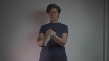 Kadın, damar sağlığını desteklemek ve trombozu önlemek için koluna baskı yapıyor. Sıkıştırma giysisi dolaşımı sağlar, varis, kan pıhtılaşması ve akciğer embolisi riskini azaltır.. 