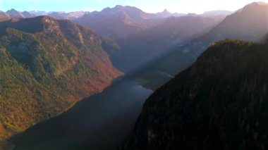Almanya 'daki Koenigssee' nin havadan görünüşü çarpıcı sonbahar renkleri ve gölün üzerinde altın gün batımı sergiliyor. Çevrelenmiş görkemli Alpler, Bavyera Berchtesgadener 'da sakin sonbahar manzarası saf doğal güzelliktir.