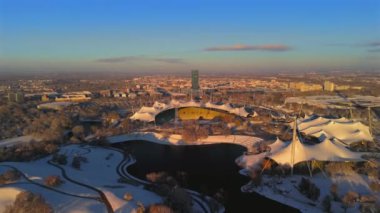 Olympiastadion im Olympiapark Munchen, Deutschland Luftaufnahme im Winter bei verschnemaddesi, sonnigem Wetter. Olimpiyat Parkı Münih 'teki Olimpiyat Stadyumu, Almanya' da kış aylarında hava durumu güneşli.. 