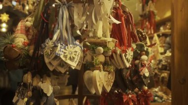 Münih, Almanya, kış akşamı. Süslü tezgahları olan atmosferik Noel pazarı. Yanıp sönen ışıklar, hediyelik eşyalı vitrinler, şenlikli süsler ve tatil süsleri büyülü bir ortam yaratır.