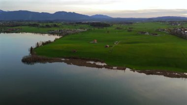 Oberbayern bei Sonnenuntergang 'dan Der Riegsee. Murnau, Bavyera, Almanya, Avrupa yakınlarındaki Riegsee Gölü 'nün havadan görüntüsü. Baharda gün batımında arka planda Ammergauer Alpen. Turizm Bölgesi Das Blaue Arazisi. 
