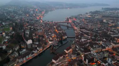 Stadtbild von Luzern Luftaufnahme, Schweiz bei Nacht mit Stadtlichtern, nebligem Wetter. Luftbild vom Fluss Reuss und allen bekannten Bruecken am Abend. Gece Lucerne şehir merkezinin havadan görünüşü