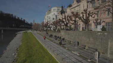 25 Aralık 2022. Salzburg, Avusturya. Güneşli kış gününde Salzburg 'da nehir üzerindeki şehir manzarası. Salzach nehir kıyısında. Salzburg, Avusturya ve Avrupa 'daki Salzach Nehri' nin seti. Salzburg Şehir Manzarası