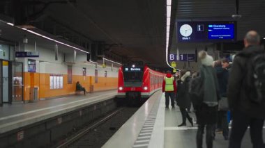 15 Kasım 2023. Münih, Almanya. Kızıl S-Bahn treni Marienplatz istasyonuna varmak üzere. Tren bekleyen bir sürü insan var. Münih, Bavyera 'da toplu taşıma. Banliyö treni. Munchen Demiryolu. 
