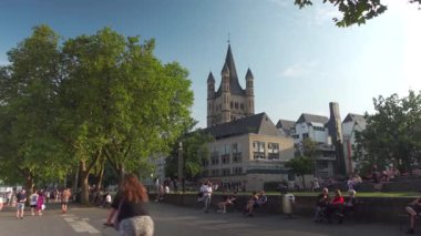 20 Temmuz 2024. Köln, Almanya. Gross Sankt Martin am Fischmarkt in Koeln, Deutschland im Sommer Blick vom Rheinufer. Büyük St. Martin Kilisesi, Köln. İnsanlar rıhtımda yürüyor ve dinleniyor.. 