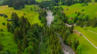 Almanya 'nın Oberstdorf kentindeki Trettach Nehri, ormanların ve dağlık arazilerin arasından esiyor. Hava manzarası temiz su, canlı doğa ve görkemli dağ zirvelerini yakalar. Huzurlu ve huzurlu bir ortam sunar.. 