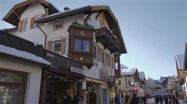 25 Aralık 2024. Garmisch-Partenkirchen, Almanya. Güneşli bir kış günü, karlı sokaklar, kapalı dükkanlar, yayalar, gezinen insanlar olan huzurlu bir kasaba. Garmisch Partenkirchen şehir merkezinde.