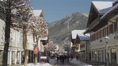 25 Aralık 2024. Garmisch-Partenkirchen, Almanya. Güneşli bir kış günü, karlı sokaklar, kapalı dükkanlar, yayalar, gezinen insanlar olan huzurlu bir kasaba. Garmisch Partenkirchen şehir merkezinde.
