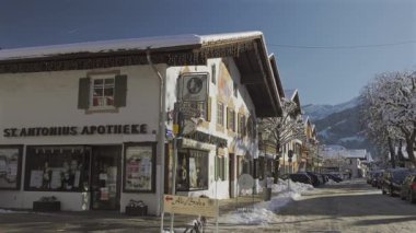 25 Aralık 2024. Garmisch-Partenkirchen, Almanya. Güneşli bir kış günü, karlı sokaklar, kapalı dükkanlar, yayalar, gezinen insanlar olan huzurlu bir kasaba. Garmisch Partenkirchen şehir merkezinde.