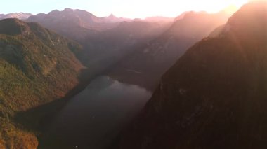 Almanya 'daki Koenigssee' nin havadan görünüşü çarpıcı sonbahar renkleri ve gölün üzerinde altın gün batımı sergiliyor. Çevrelenmiş görkemli Alpler, Bavyera Berchtesgadener 'da sakin sonbahar manzarası saf doğal güzelliktir.