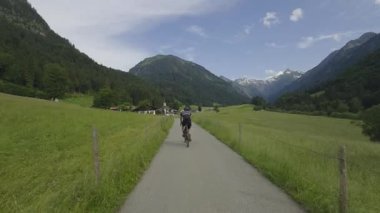 Almanya, Oberstdorf yakınlarındaki Bavyera Alpleri 'nde bisiklet süren insan, hayranlık uyandıran manzaralar keşfediyor. Bisiklet, doğa ve macera turizmi için mükemmel bir yer.. 