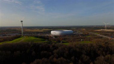 Froettmaninger Tepesi 'nin hava manzarası, rüzgar türbini ve Münih' teki Allianz Arena manzarası. Freimann rüzgar santrali ve Münih futbol sahası yukarıdan ele geçirildi. 