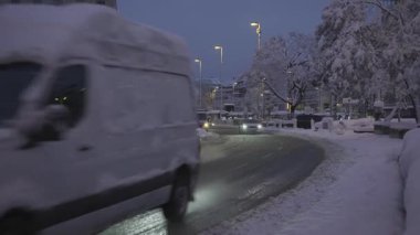 20 Aralık 2024. Münih, Almanya. Muenchen 'de karlı bir akşam, yoğun kar yağışı sokakları, arabaları ve ağaçları kaplıyor. Şehir ışıkları parlıyor, trafik yavaş ilerliyor. Karlsplatz rekor kıran karla kaplıdır.. 