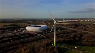 Rüzgâr türbinli Froettmaninger Mullberg 'in hava görüntüsü ve Münih' teki Allianz Arena 'nın net bir görüntüsü. Freimann rüzgar türbini ve Münih futbol arenasının kuş bakışı perspektifi. 