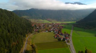 Bayern 'deki Bayrischzell Gemeinde, Deutschland Luftaufnahme im Herbst. Almanya 'nın Bavyera kentindeki Bayrischzell şehrinin sonbaharda güneşli bir havada Alpler tarafından çevrelenmiş havadan görünüşü. Urlaub Oberbayern 'de. 