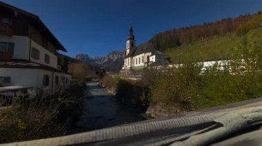 Almanya, Ramsau 'daki Aziz Sebastian Kilisesi. Güneşli gökler vadiden ve görkemli dağlardan akan nehirler seyahat ve turizm için mükemmel manzaralar yaratıyor. Kirche Ramsau bei Berchtesgaden 'de.. 