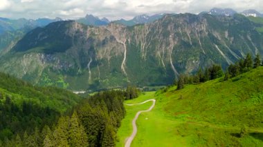 Almanya 'nın Oberstdorf yakınlarındaki Bavyera Alpleri' nin hava manzarası Fellhorn 'a giden dolambaçlı dağ yolu. Önplandaki görkemli dağ sırası Almanya ve Avusturya 'yı ayırarak alp manzarası oluşturur.. 
