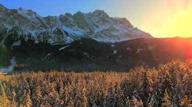 Alman Bavyera Alpleri 'ndeki kar kaplı ağaç tepelerinde nefes kesen hava manzarası, Zugspitze kitsif sergileniyor. Zugspitze Gipfel Wetterstein Dağları 'nın en yüksek zirvesi ve Almanya' nın en yüksek dağı. 