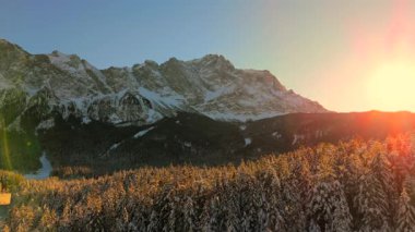 Alman Bavyera Alpleri 'ndeki kar kaplı ağaç tepelerinde nefes kesen hava manzarası, Zugspitze kitsif sergileniyor. Zugspitze Gipfel Wetterstein Dağları 'nın en yüksek zirvesi ve Almanya' nın en yüksek dağı. 