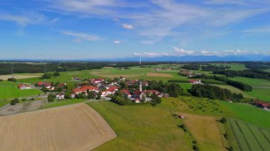 Pfarrkirche St. Michael, Bayern 'deki Alxing und Windfarm, Deutschland Luftaufnahme. Rüzgâr türbini köy kilisesinin hava manzarasının arkasında. Alxing Blick süper Pfarrkirche St. Michael auf Osterklinger Windrad. 