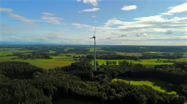 Almanya 'nın Ebersberg bölgesindeki Bavyera' daki rüzgar türbininin hava görüntüsü. Bayern, Deutschland 'deki Luftaufnahme einer Windtürbin vor dem Hintergrund der Alpen. Alplere bakan golf sahasında rüzgar türbini. 