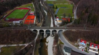 Traunsteiner Viaduct 'un hava görüntüsü, Almanya' nın Bavyera bölgesindeki Rosenheim-Salzburg hattındaki taş demiryolu köprüsü. Beş kemerli Traun Nehri manzaralı bahar manzaraları arasında uzanıyor. Luftaufnahme, Deutschland. 