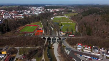 Almanya, Bavyera 'daki tarihi Traunsteiner Viaduct' un hava manzarası. Bu çarpıcı taş demiryolu köprüsü Traun Nehri boyunca uzanır. Parlak, güneşli gökyüzünün altında bereketli bahar manzaralarıyla çevrili.. 