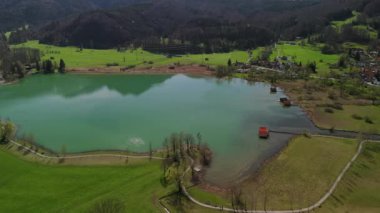 Schlehdorf, Bavyera, Almanya yakınlarındaki Kochelsee Gölü 'nün havadan görünüşü. Yeşil suyu, ahşap kayıkhaneleri ve huzurlu bir kıyı şeridi olan manzaralı bir yaz manzarası. Mükemmel bir doğa inzivası ve seyahat yeri.
