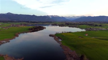 Oberbayern bei Sonnenuntergang 'dan Der Riegsee. Murnau, Bavyera, Almanya, Avrupa yakınlarındaki Riegsee Gölü 'nün havadan görüntüsü. Baharda gün batımında arka planda Ammergauer Alpen. Turizm Bölgesi Das Blaue Arazisi. 