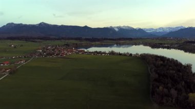 Oberbayern bei Sonnenuntergang 'dan Der Riegsee. Murnau, Bavyera, Almanya, Avrupa yakınlarındaki Riegsee Gölü 'nün havadan görüntüsü. Baharda gün batımında arka planda Ammergauer Alpen. Turizm Bölgesi Das Blaue Arazisi. 