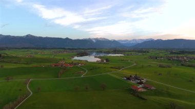 Oberbayern bei Sonnenuntergang 'dan Der Riegsee. Murnau, Bavyera, Almanya, Avrupa yakınlarındaki Riegsee Gölü 'nün havadan görüntüsü. Baharda gün batımında arka planda Ammergauer Alpen. Turizm Bölgesi Das Blaue Arazisi. 