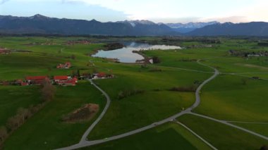 Oberbayern bei Sonnenuntergang 'dan Der Riegsee. Murnau, Bavyera, Almanya, Avrupa yakınlarındaki Riegsee Gölü 'nün havadan görüntüsü. Baharda gün batımında arka planda Ammergauer Alpen. Turizm Bölgesi Das Blaue Arazisi. 