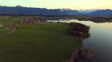 Oberbayern bei Sonnenuntergang 'dan Der Riegsee. Murnau, Bavyera, Almanya, Avrupa yakınlarındaki Riegsee Gölü 'nün havadan görüntüsü. Baharda gün batımında arka planda Ammergauer Alpen. Turizm Bölgesi Das Blaue Arazisi. 