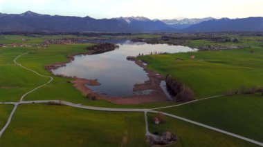 Oberbayern bei Sonnenuntergang 'dan Der Riegsee. Murnau, Bavyera, Almanya, Avrupa yakınlarındaki Riegsee Gölü 'nün havadan görüntüsü. Baharda gün batımında arka planda Ammergauer Alpen. Turizm Bölgesi Das Blaue Arazisi. 