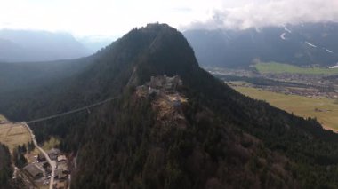 Avusturya, Tyrol, Reutte yakınlarındaki Ehrenberg Kalesi 'nin havadan görüntüsü. Ortaçağ Ehrenberg kalıntıları, Schlosskopf Kalesi ve çarpıcı Lechtal Alpleri 'ndeki ikonik Highline179 asma köprüsü.. 