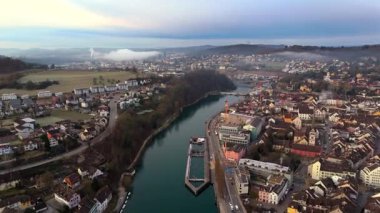 İsviçre 'nin Schaffhausen kentinin havadan görünüşü, Ren Nehri' nin güneşin doğuşuyla birlikte tarihi şehri sarmasıyla çatılar ve altın ışık nefes kesici bir manzara yaratıyor. Luftaufnahme des Rheins in der Schweiz. 